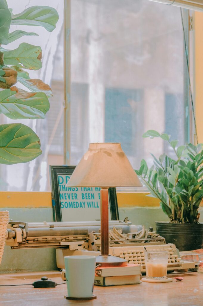 A serene vintage workspace featuring a classic typewriter, warm lighting, and lush plants.