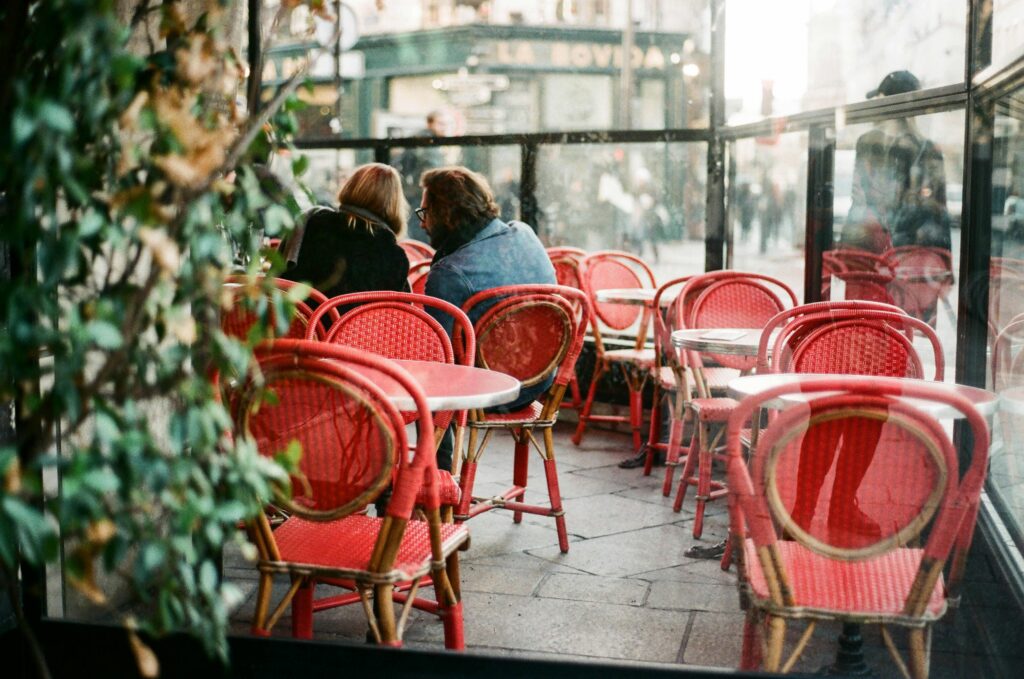 Romantic scene at a Parisian café featuring red chairs and a cozy ambiance.