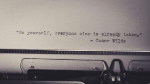 Vintage typewriter displaying Oscar Wilde's quote 'Be yourself, everyone else is already taken.'